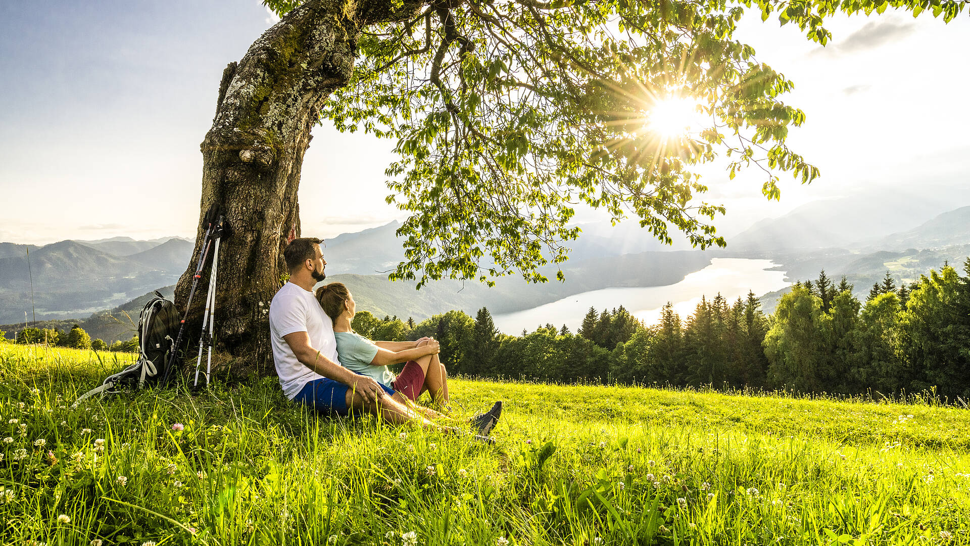 Mann und Frau sitzen im Schatten eines Baumes in der Via Paradiso.