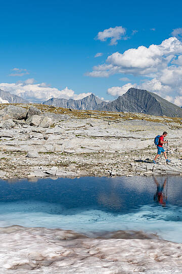 Pärchen beim Wandern am Tauernhöhenweg entlang eines Bergsees