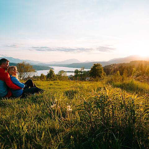 Eine Frau und ein Mann sitzen und machen eine Pause beim Wandern auf dem Wowrthersee-Rundwanderweg am Pirkerkogel.